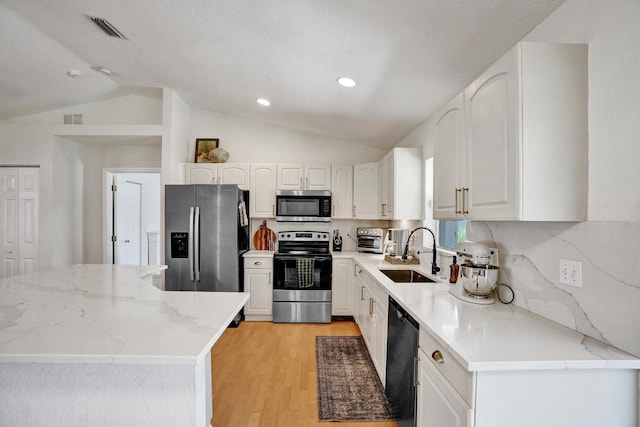 kitchen featuring visible vents, light wood-style flooring, appliances with stainless steel finishes, and a sink