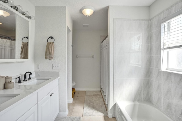 full bath with tile patterned flooring, double vanity, plenty of natural light, and a sink