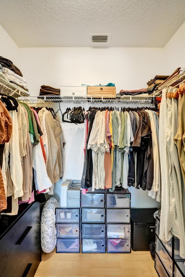 walk in closet featuring visible vents and wood finished floors