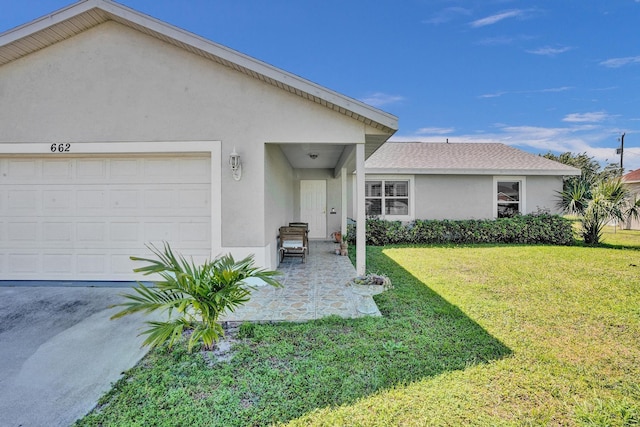 view of front of home with stucco siding, an attached garage, a shingled roof, and a front yard