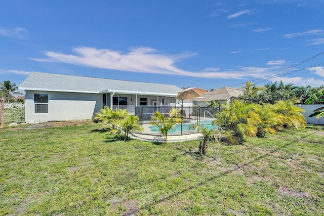 back of property with a lawn, a fenced in pool, a fenced backyard, and stucco siding