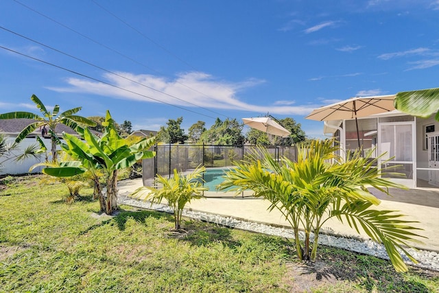 view of yard featuring a fenced in pool, fence, a patio, and a sunroom