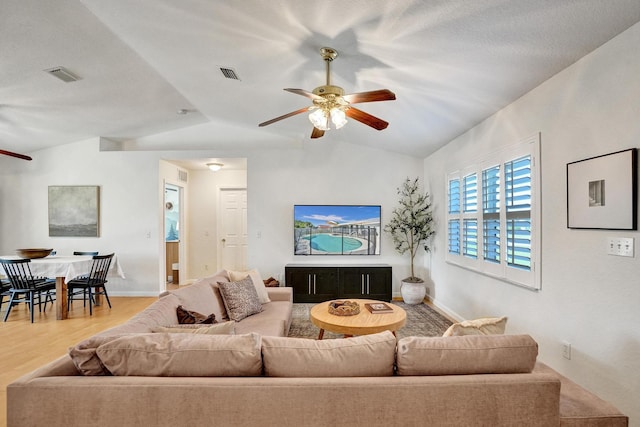 living area featuring visible vents, wood finished floors, ceiling fan, and vaulted ceiling