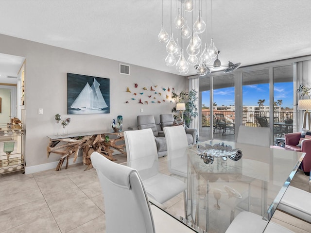 tiled dining space with visible vents, a textured ceiling, and baseboards