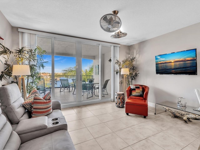 living room featuring expansive windows, a textured ceiling, and tile patterned flooring