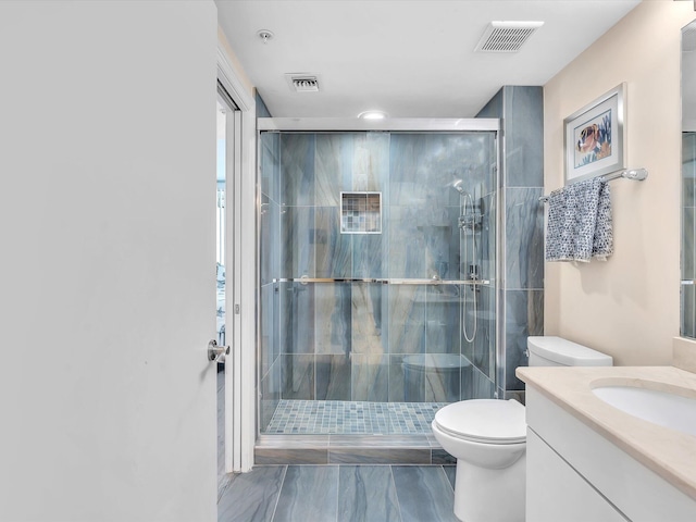 full bath featuring vanity, toilet, visible vents, and a stall shower