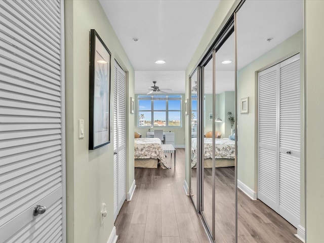 hall with baseboards and wood finished floors