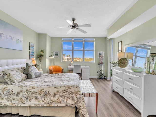 bedroom with light wood-type flooring, multiple windows, baseboards, and ceiling fan