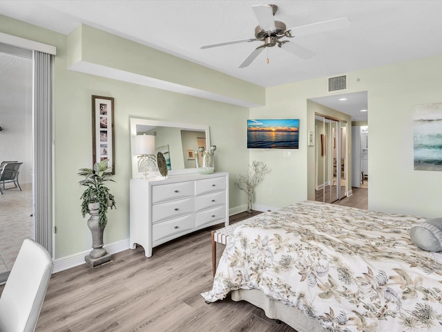 bedroom featuring visible vents, baseboards, light wood-style flooring, and a ceiling fan