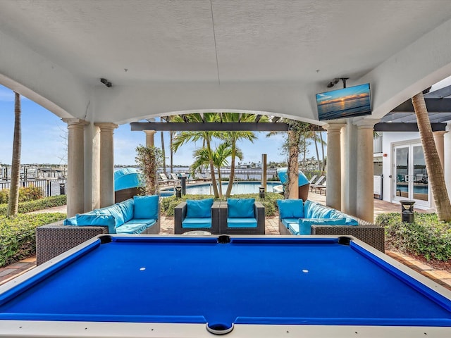 game room with decorative columns, a textured ceiling, and pool table