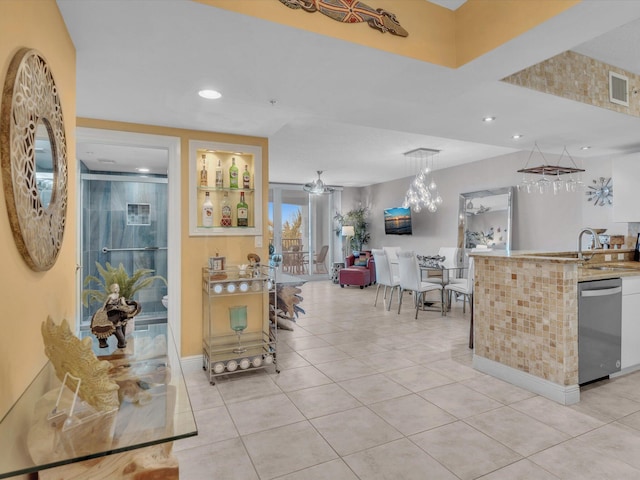 kitchen featuring visible vents, ceiling fan, stainless steel dishwasher, light tile patterned flooring, and a sink