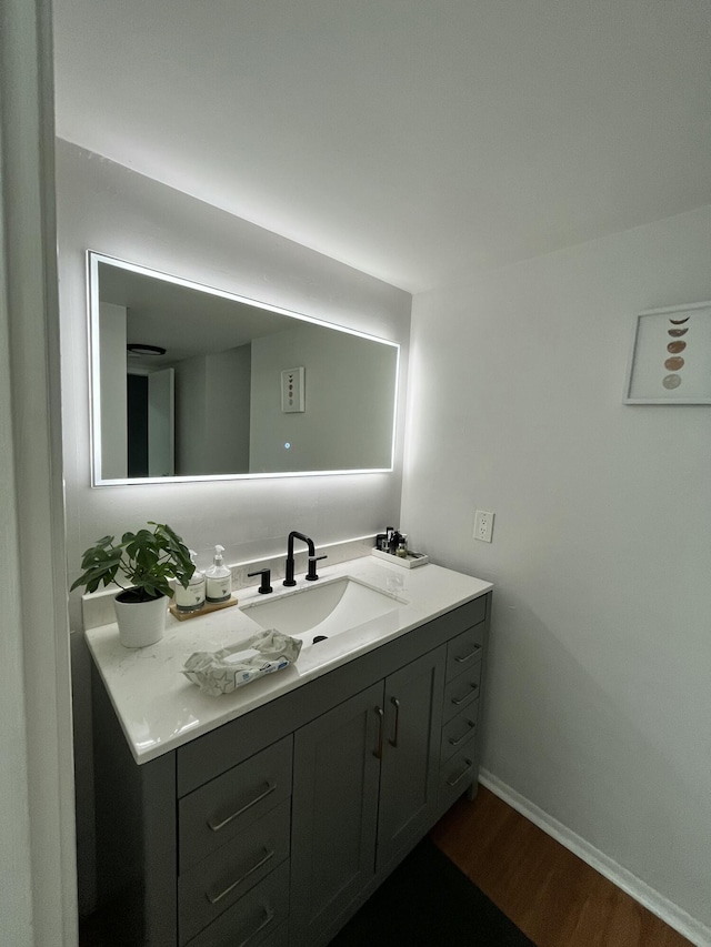 bathroom with vanity, baseboards, and wood finished floors