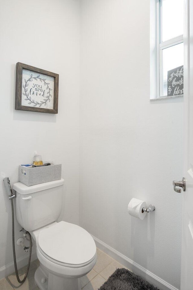 bathroom featuring toilet, baseboards, and tile patterned floors