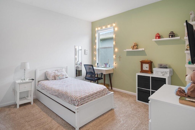 bedroom featuring light carpet and baseboards