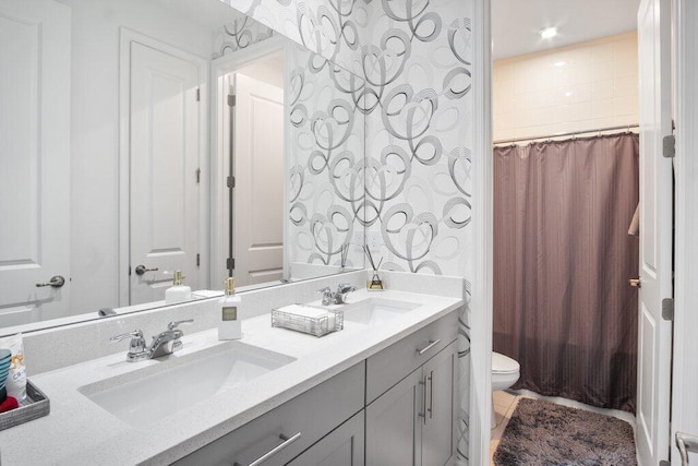 bathroom featuring toilet, tile patterned flooring, double vanity, and a sink