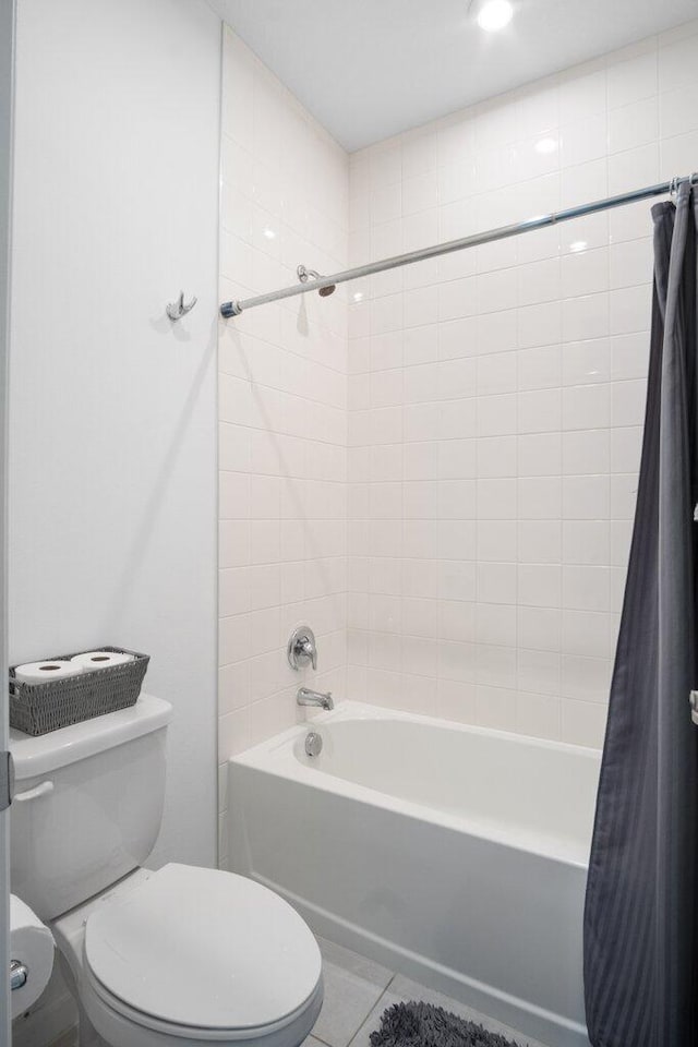 bathroom with shower / tub combo, tile patterned flooring, and toilet