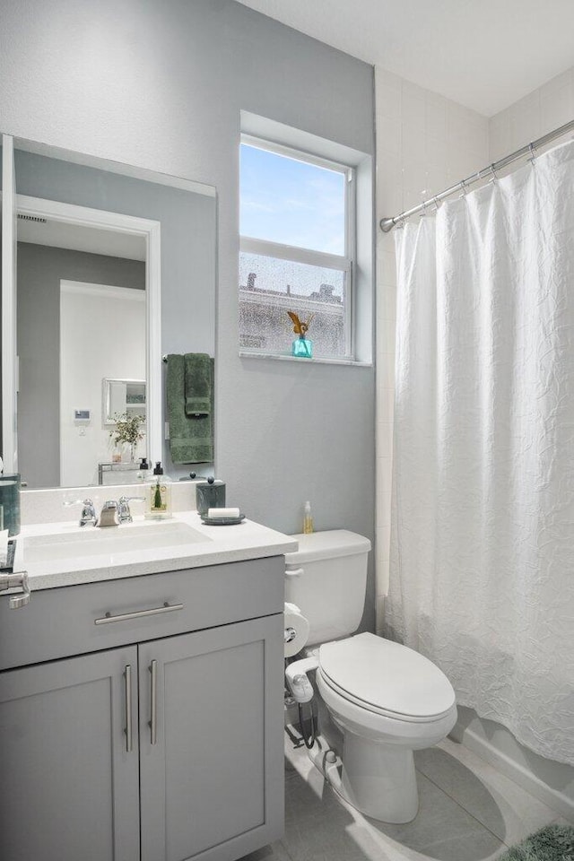 full bathroom with vanity, toilet, and tile patterned floors