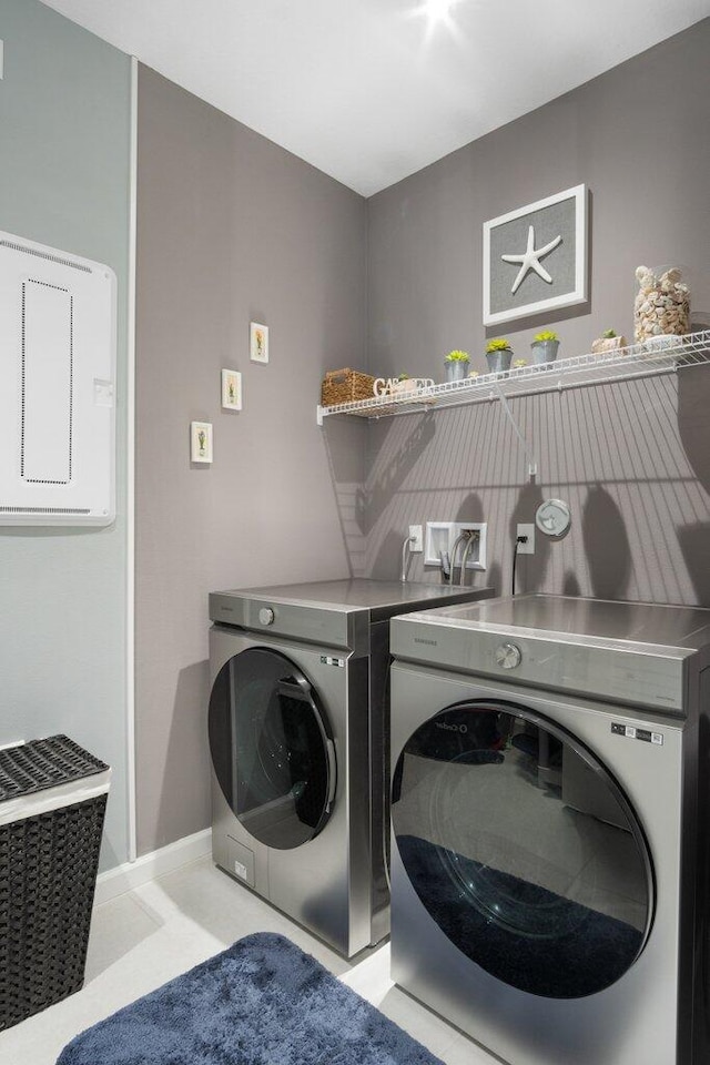 washroom with laundry area, washer and clothes dryer, and baseboards