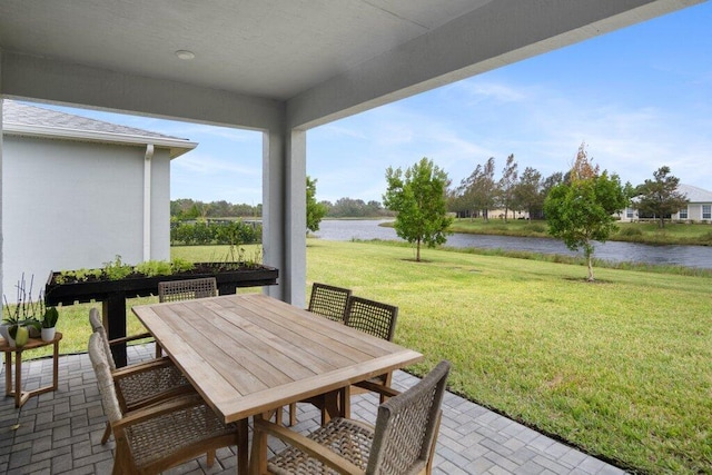 view of patio with outdoor dining area and a water view