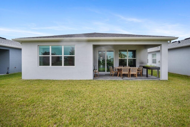 back of property featuring a yard, roof with shingles, a patio area, and stucco siding