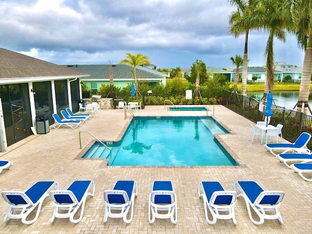 pool with a patio and fence