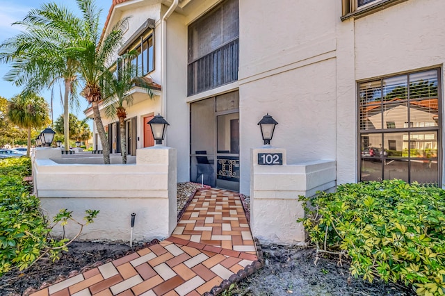 doorway to property featuring stucco siding