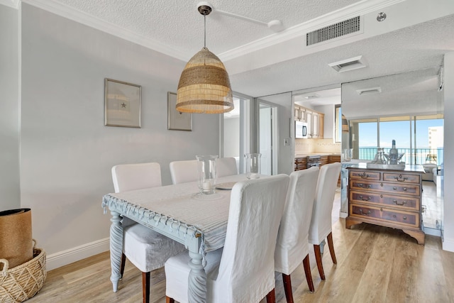 100 Ocean Trail Way Unit 1101, Jupiter, FL 33477 - dining area with a textured ceiling, light wood-type flooring, crown molding, and baseboards
