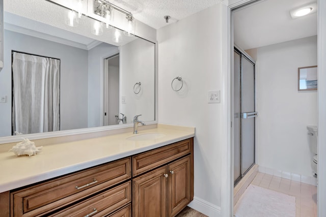 bathroom with tile patterned floors, a shower stall, a textured ceiling, and vanity