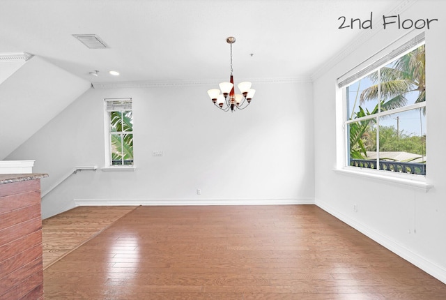 interior space with a wealth of natural light, visible vents, an inviting chandelier, and hardwood / wood-style floors