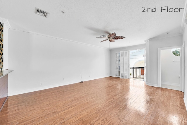 unfurnished living room featuring visible vents, ornamental molding, a ceiling fan, and wood finished floors