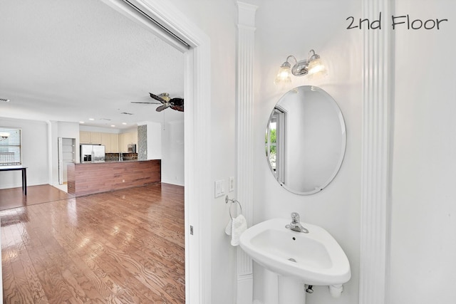 bathroom with ceiling fan, wood finished floors, a wealth of natural light, and a sink