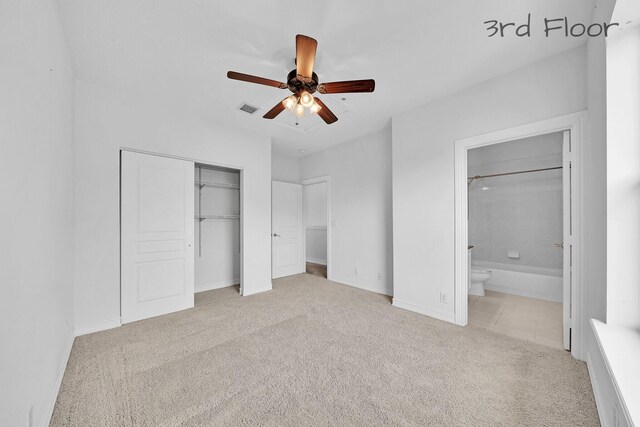 unfurnished bedroom featuring visible vents, ensuite bath, a closet, carpet flooring, and baseboards