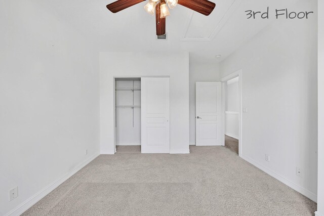 unfurnished bedroom featuring light colored carpet, a closet, and baseboards