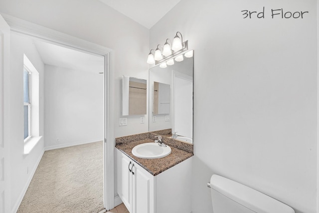 bathroom featuring vanity, toilet, and baseboards