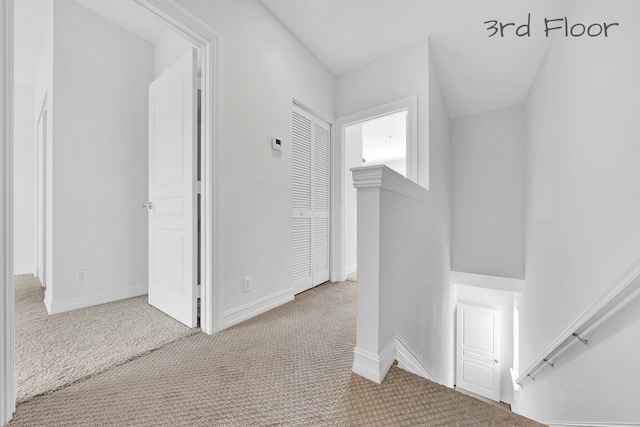 hall with baseboards and carpet flooring