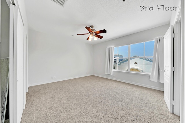 interior space with a ceiling fan, carpet, visible vents, and baseboards