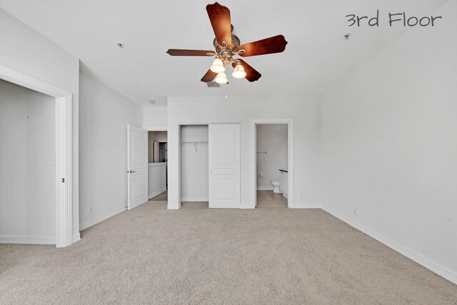 unfurnished bedroom featuring baseboards, ceiling fan, a closet, light carpet, and connected bathroom