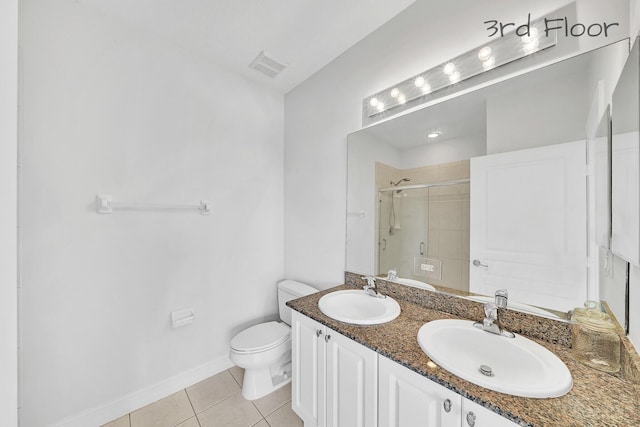 full bathroom featuring tile patterned floors, toilet, a stall shower, and a sink