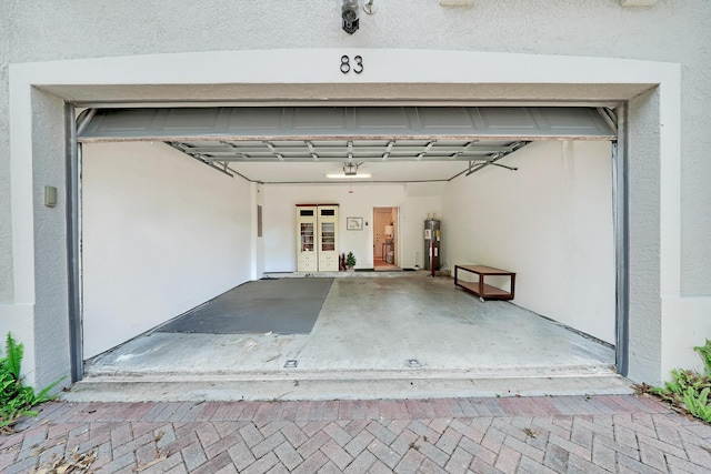 garage with decorative driveway and electric water heater