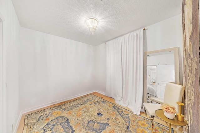 unfurnished room featuring a textured ceiling and baseboards