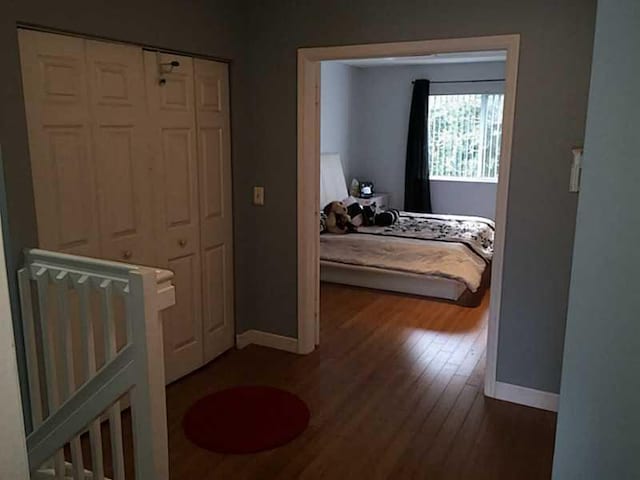 bedroom with wood finished floors and baseboards