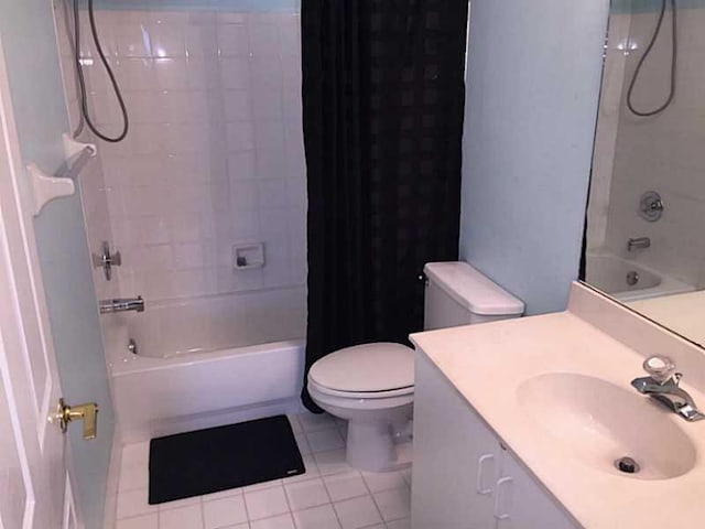 full bath with toilet, tile patterned flooring, shower / bath combo with shower curtain, and vanity