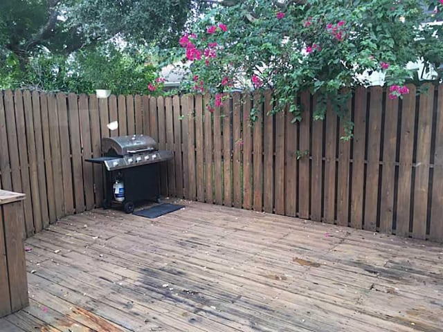 deck with a grill and fence