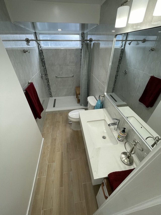 full bath featuring vanity, toilet, a stall shower, and wood tiled floor