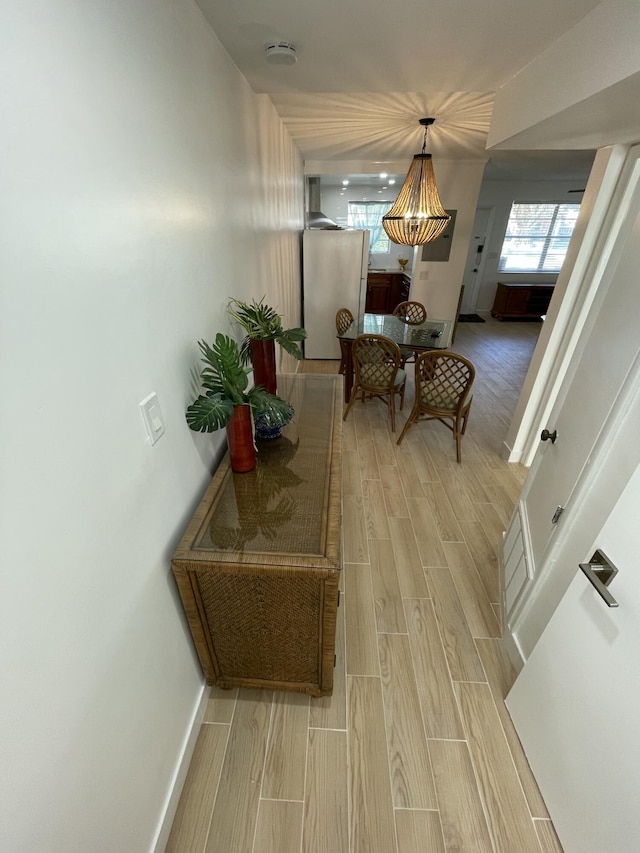 hallway featuring wood finish floors and baseboards