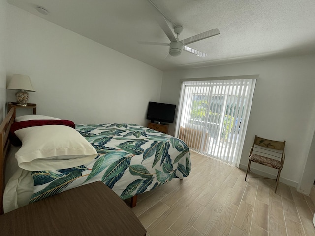 bedroom with a textured ceiling, light wood-style flooring, a ceiling fan, and access to outside