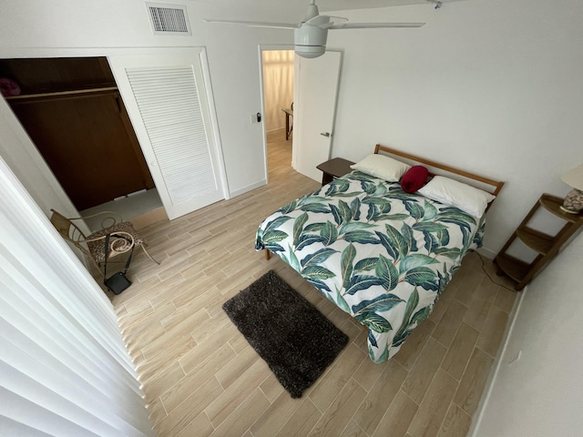 bedroom featuring ceiling fan, baseboards, visible vents, and wood finish floors