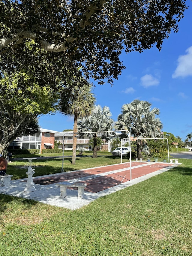 surrounding community with shuffleboard and a lawn