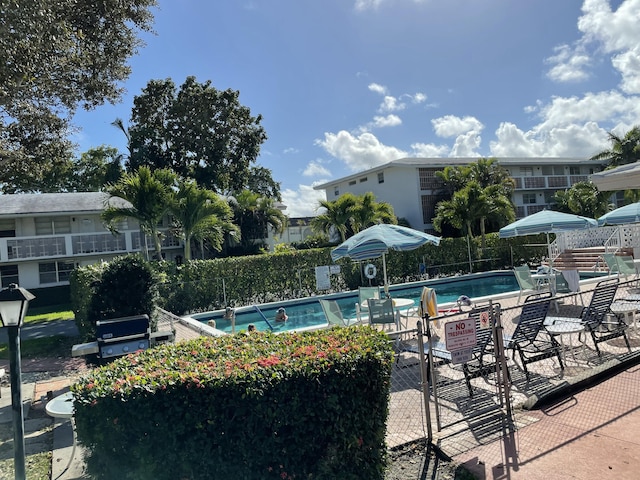 pool featuring a patio area, a grill, and fence