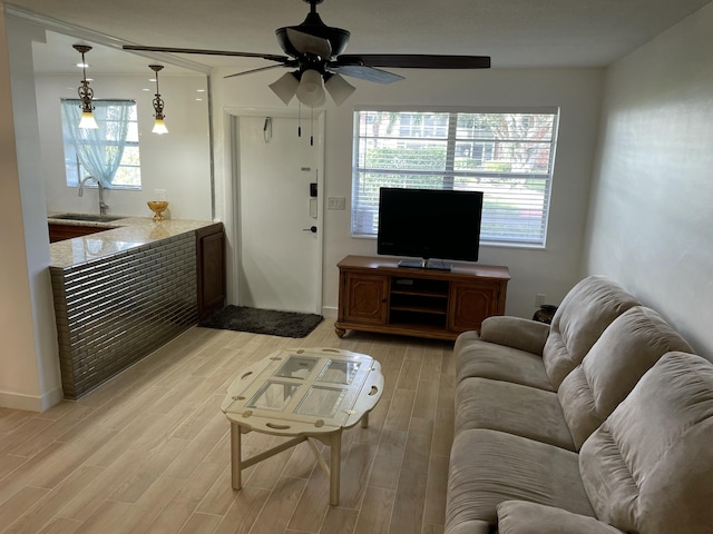 living area featuring light wood-style flooring and ceiling fan